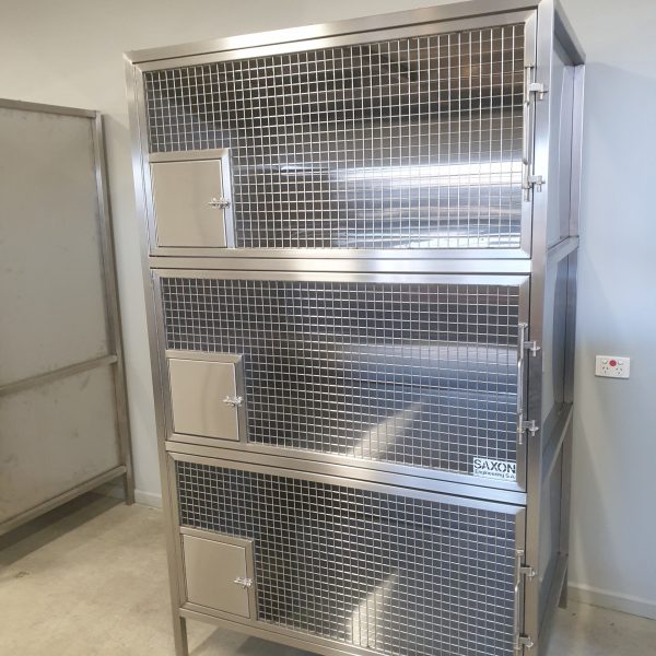 Stainless steel fabrication: vet cages. 1 unit with 3 sections vertically stacked each front is a large door with mesh front and small square sheet metal door in the bottom left corner. Each door is securely locked. The rest of the cage is sheet metal all 2B finish 316 stainless steel.